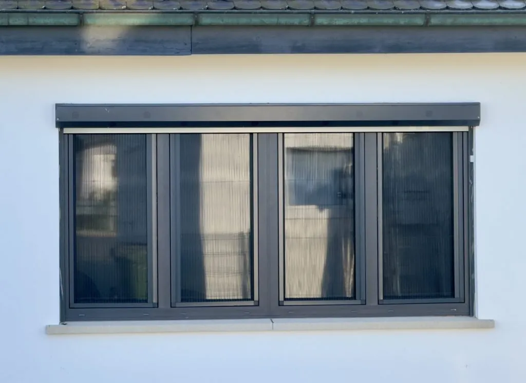 Breites Fenster mit dunklem Insektenschutz-Plissee